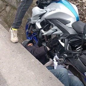 男子骑行掉沟被压车下路人抬车相救