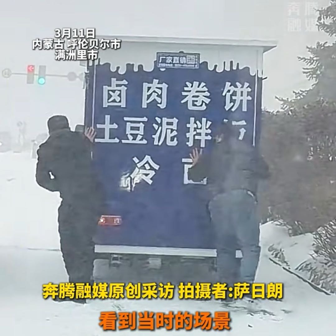 暴雪中餐车原地打滑两男子冒雪上前推车