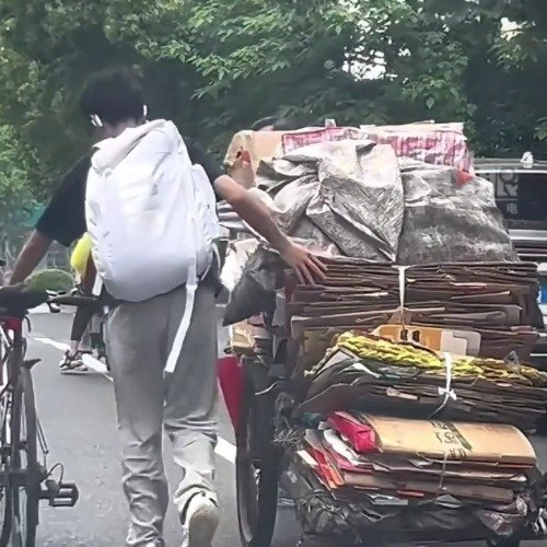 大叔拉纸壳上坡骑行小伙下车帮忙