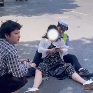 女警坐地上为摔倒孕妇支撑