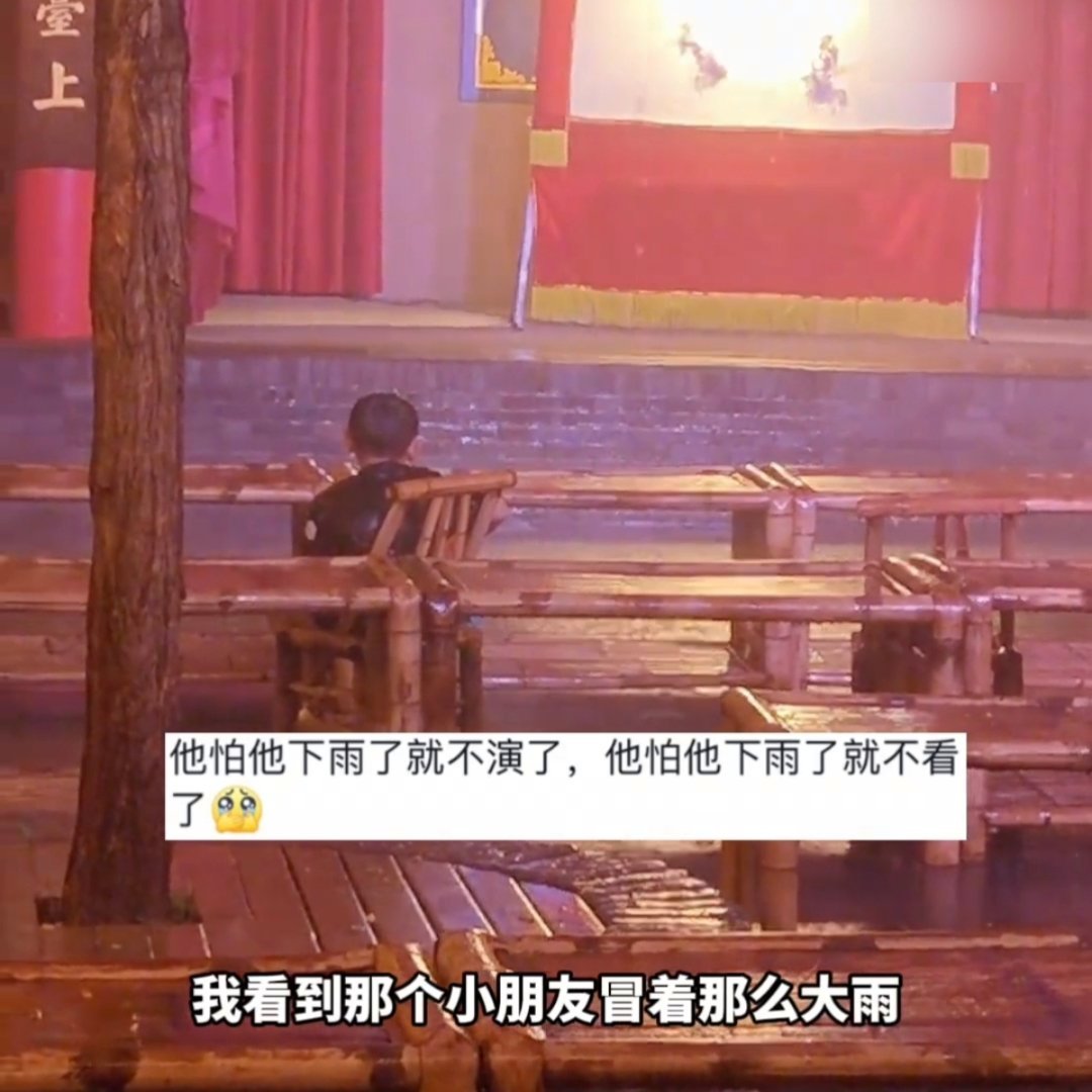 小孩哥冒雨欣赏皮影戏