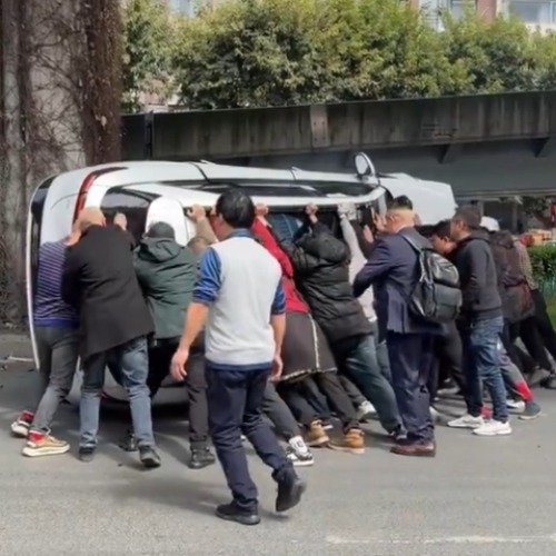 成都街头一车辆侧翻众人合力抬车